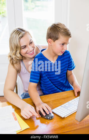 Mother and son using computer in living room Stock Photo