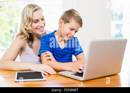 Happy mother and son using laptop Stock Photo
