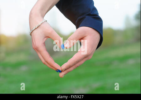 Close up of woman and man hands showing heart shape Stock Photo