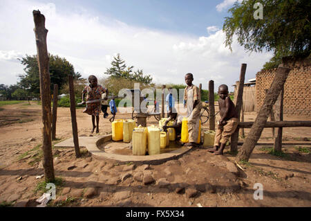 Children gathering water from a well in Uganda, Africa Stock Photo