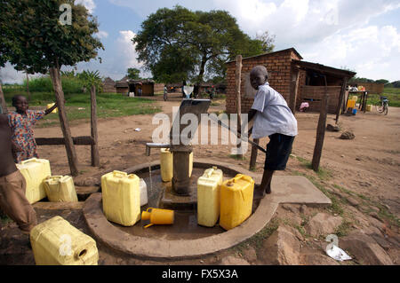 Child gathering water from a well in Uganda, Africa Stock Photo