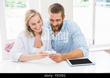 Smiling couple using a mobile phone Stock Photo
