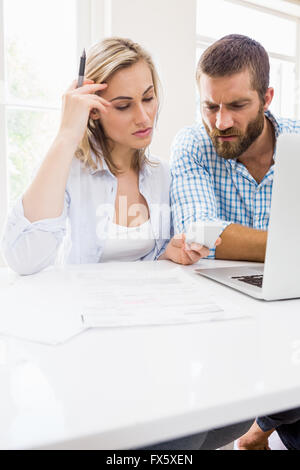 Worried couple looking at mobile phone Stock Photo