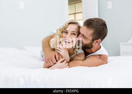 Young couple embracing on bed Stock Photo