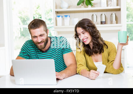 Couple using laptop while having coffee Stock Photo