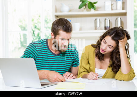Couple checking their bills in kitchen Stock Photo