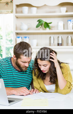 Couple checking their bills in kitchen Stock Photo