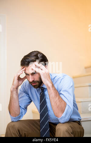 Worried man sitting on stairs Stock Photo