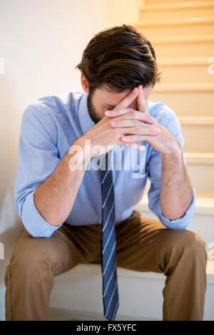 Worried man sitting on stairs Stock Photo