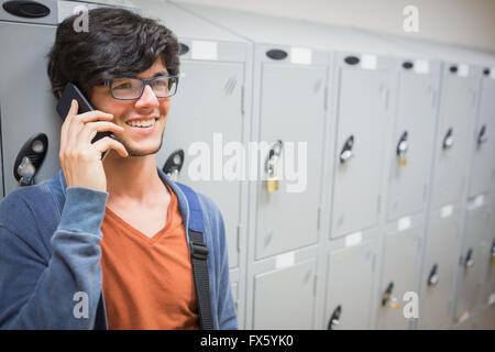 Happy student talking on phone in locker room Stock Photo