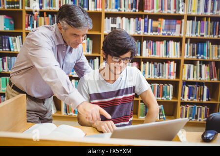 Professor assisting a student with laptop Stock Photo