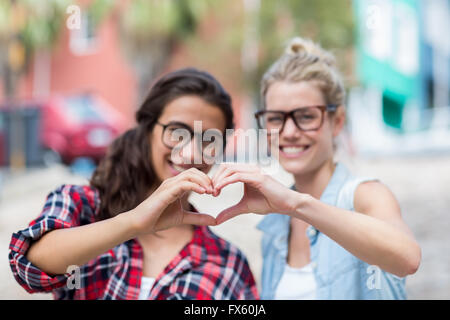 Friends making heart shape with hands Stock Photo