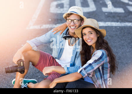 Young couple sitting on road Stock Photo