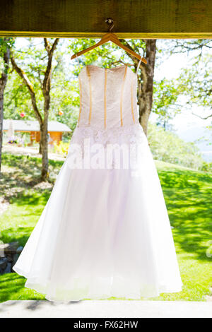 Wedding dress hanging up for a photo at a winery in Southern Oregon. Stock Photo