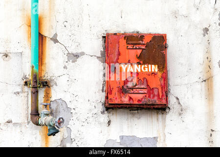 Fire fighter box for fire hose and water valve on an weathered wall of the old building Stock Photo
