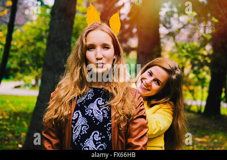 Caucasian women playing with autumn leaves Stock Photo