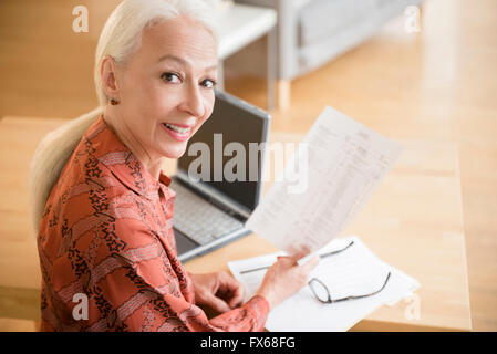 Caucasian woman paying bills on laptop Stock Photo