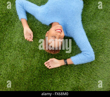 Mixed race woman laying in grass Stock Photo