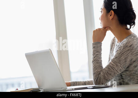 Hispanic woman sitting at laptop Stock Photo