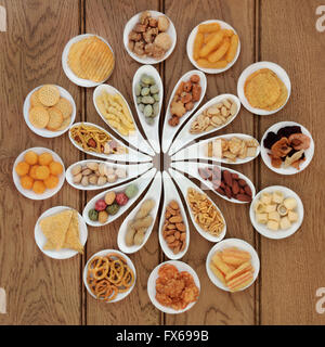 Savory snack food selection in porcelain dishes over oak background. Stock Photo