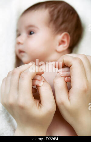 Little palms of newborn baby in mother's hands Stock Photo