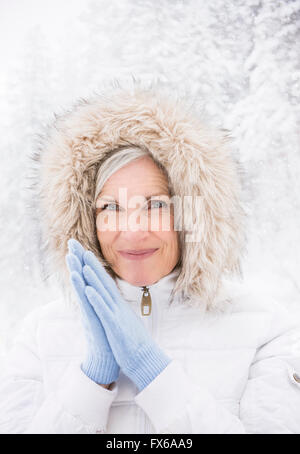 Caucasian woman wearing fur hood in snow Stock Photo