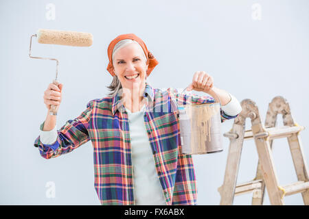 Caucasian woman painting in new home Stock Photo