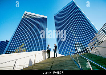 Businessmen talking under highrise buildings Stock Photo