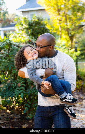 Father kissing son outdoors Stock Photo