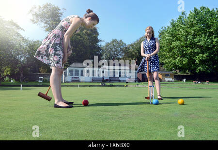 Caucasian women playing croquet on lawn Stock Photo