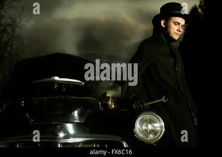 Caucasian man working on broken-down vintage car Stock Photo