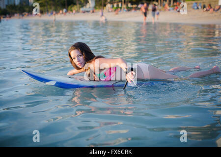 Mixed race amputee swimming with surfboard Stock Photo