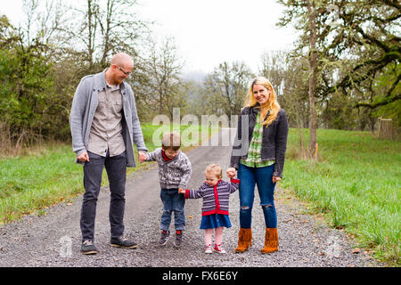 Family photo of a mother, father, and their two kids a boy and girl outdoors in the Fall. Stock Photo