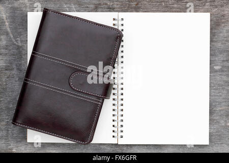 brown leather organizer and spiral notebook on grunge wood background Stock Photo