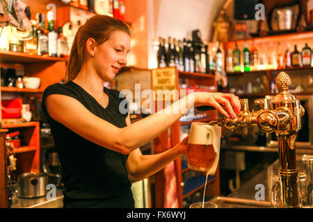 Prague bar in Mala Strana Young woman waitress serving beer, 'U Zavesenyho kafe bar Prague Czech Republic beer pint tap Stock Photo