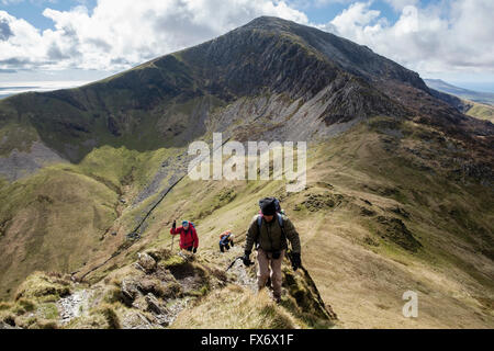 Hikers ascending path up Mynydd Tal-y-mignedd with view west to Craig Cwm Silyn on Crib Nantlle Ridge in Snowdonia National Park mountains. Wales UK Stock Photo