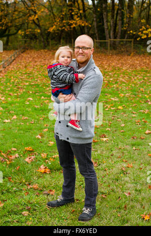 Lifestyle portrait of a father and his daugher outdoors in the Fall. Stock Photo