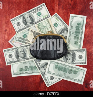 Purse placed on center of money dollar and wood background, business concept Stock Photo