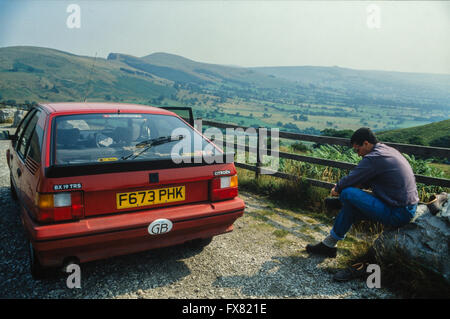 Archive image of a red 1988 model Citroën BX19 TRS 5-door hatchback compact saloon car, Mam Tor, Peak District, Derbyshire, England, 1988 with a male walker putting on hiking boots Stock Photo
