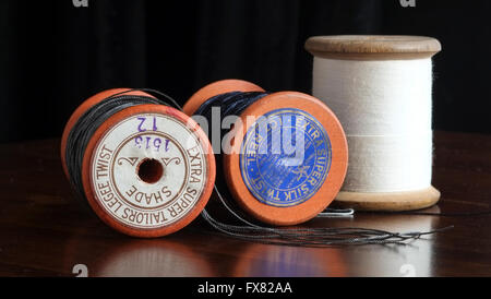 Three vintage taylor's cotton bobbin reels with blue, grey and white thread Stock Photo
