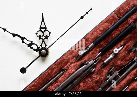 Set of drawing instrument in box near clock Stock Photo