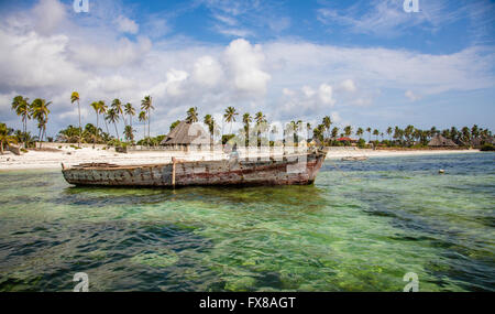 Old dhow boat and palm fringed beach on the east Zanzibar coast near Mchanga Stock Photo