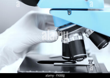 close up of scientist hand setting microscope Stock Photo