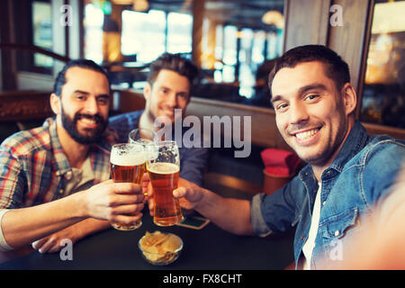 friends taking selfie and drinking beer at bar Stock Photo