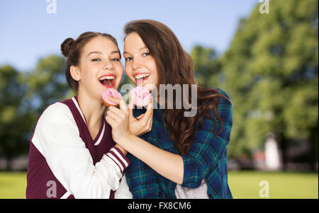 happy pretty teenage girls eating donuts Stock Photo