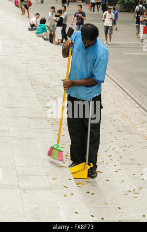 Man sweeping Orchard Road steps, Singapore. Stock Photo