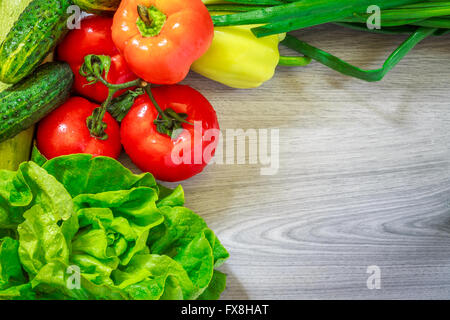 Fresh vegetables arranged around frame on grey wooden background. Flat lay with copy space Stock Photo