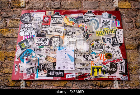 Square street sign covered in graffiti, scribbles and stickers in the trendy area near Brick lane, Shoreditch, East London. Stock Photo