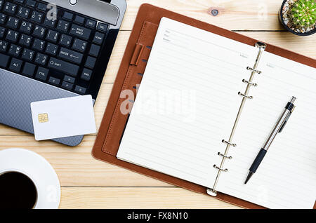 Leather notebook with pen, credit card and labtop on office desk.Top view online shopping Stock Photo