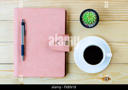 Leather notebook with pen and cup of coffee on wooden table.Top view Stock Photo